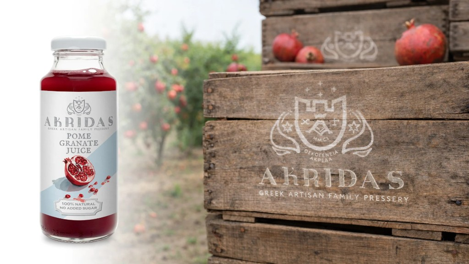 Akridas pomegranate juice bottle with English label (100% natural, no added sugar) beside branded wooden crates and pomegranates, orchard in the background